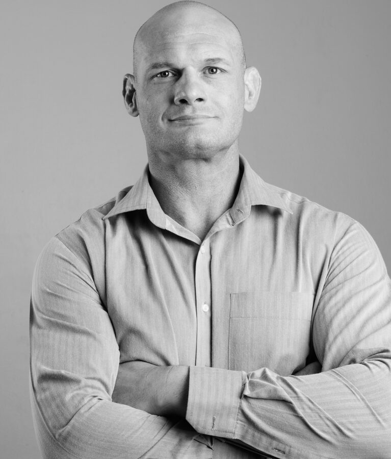 Studio shot of bald businessman against gray background in black and white