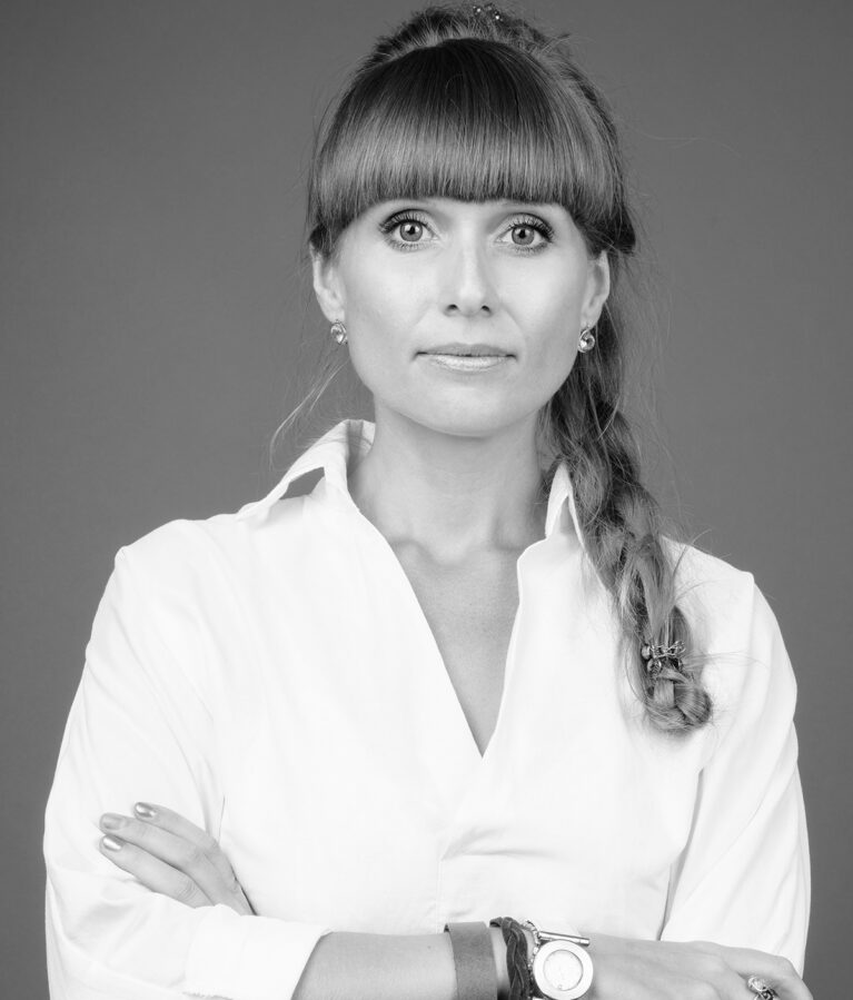 Studio shot of young beautiful businesswoman against gray background in black and white